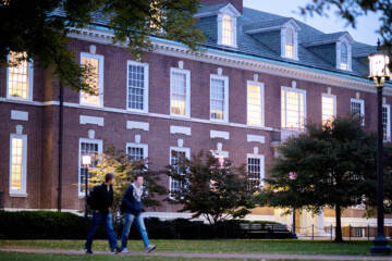 two students walk past a JHU campus building